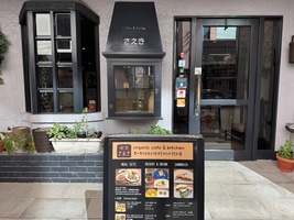restaurant entrance with shite walls and black wooden door and window frames, sign up front