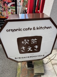 street sign for organic cafe and kitchen in english and japanese