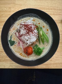 creamy soup with various vegetables bobbing at the surface