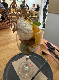 wine glass with several scoops of ice cream, fruit and decoration