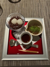 top view of desert in two bowls and a glass, various brown goos and white balls on a square plate
