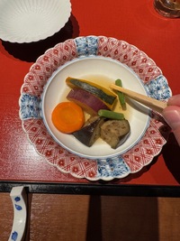 Kaiseki dinner: top view of an ornamented round plate with mixed veggies and sauce
