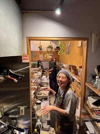 tiny kitchen area with three staff laughing into the camera