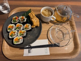 tray with plate of vegan sushi, a cup of soup and a glas tea pot
