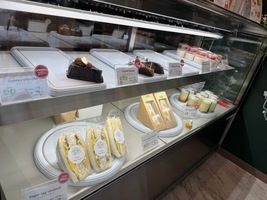 a café display of cakes and sandwiches