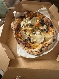 vegan pizza with thick crust, half melted mozzarella slices visible